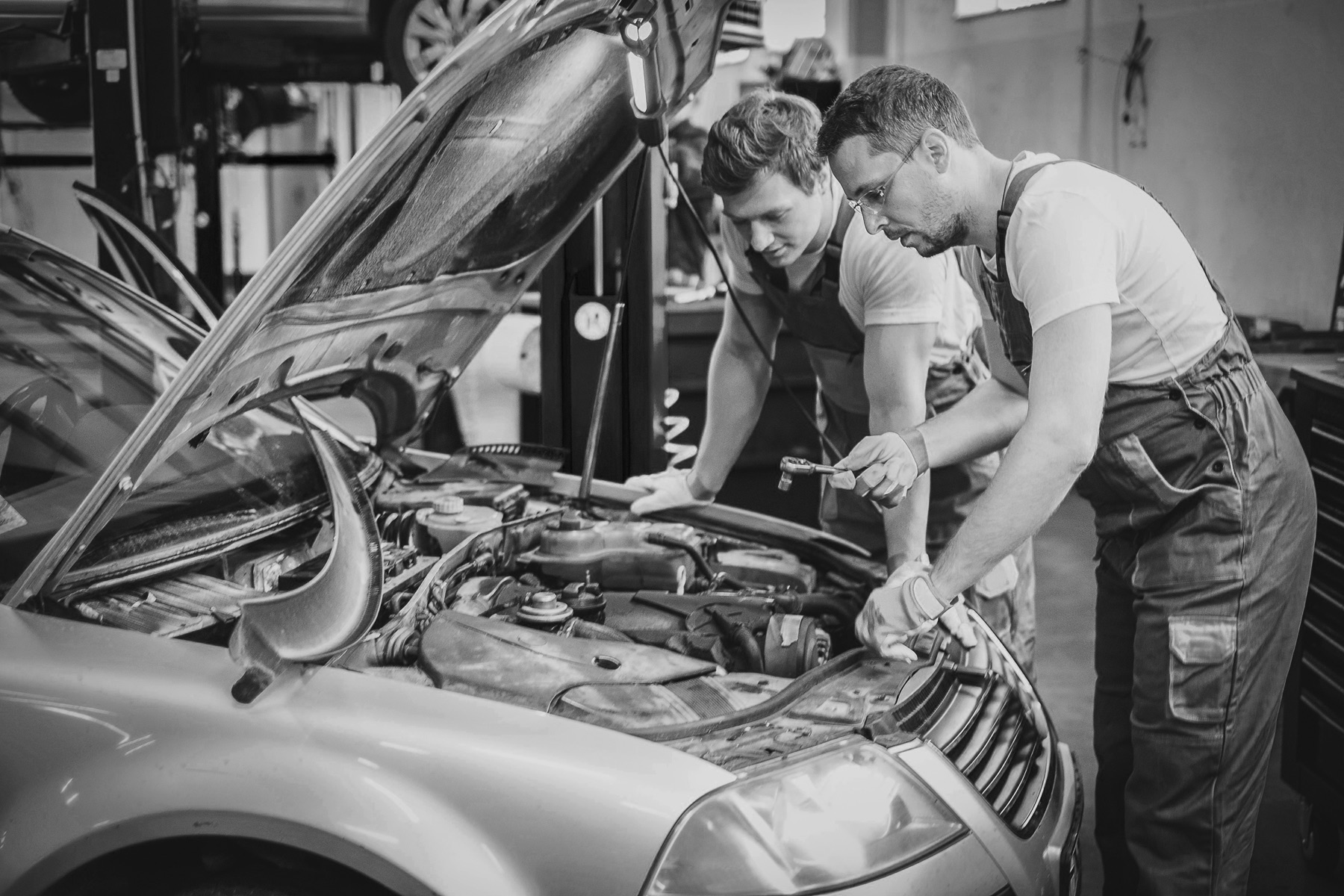 Technicians inspecting a vehicle engine